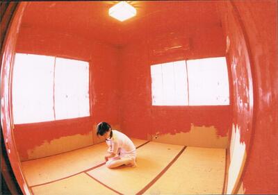 The room wall keeps reddens. The body is in a squatting pose.