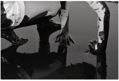 A body is reflected in the black pool.