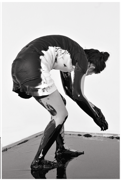 A standing, curled-up upper body, a black line drawn in space.