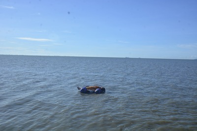 Lying on the water, being swept away