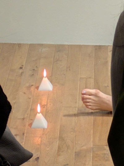 A burning candle with my feet right next to it
