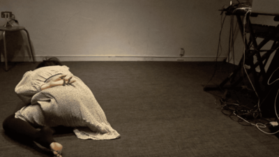 Face down, the body curls; the left hand twists and rests on the lower back
