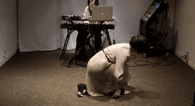 Risa plays the keyboard with her right hand extended; a crouching-start posture