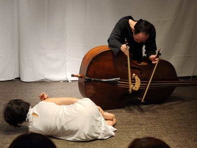 The instrument laid sideways, played from above with two bows; in the foreground, Ihoda curls