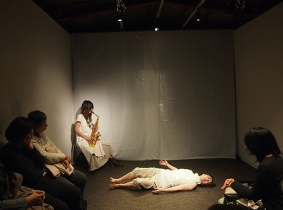 Koketsu plays seated on a chair; Ihoda’s body begins to move