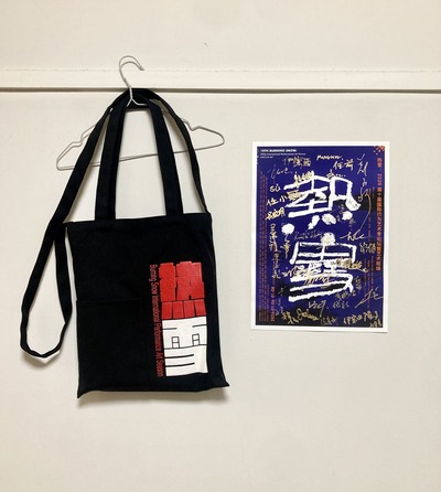 Black canvas bag with Burning Snow logo, signed A3 poster