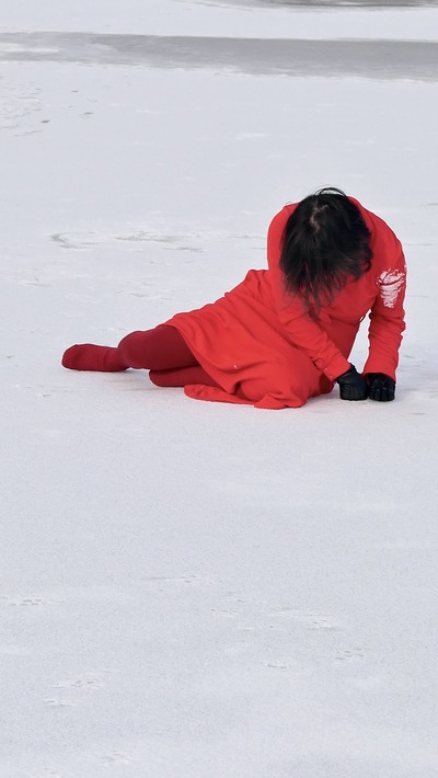 The upper body rises; white ice powder clings to the left upper arm
