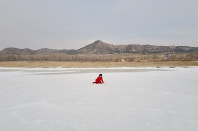 The red on the ice forms the same triangular shape as the distant mountains