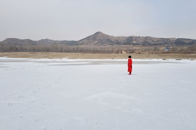 Standing on a wide, white, frozen horizontal plane: a small red vertical
